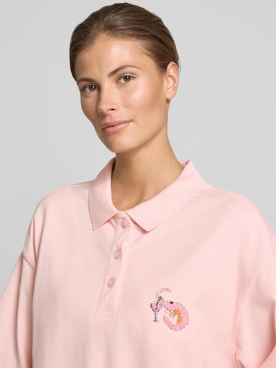 Frauenmodel trägt Cropped Poloshirt mit Ziersteinbesatz von Smith and Soul in zartem Rosa, elastischer Baumwoll-Mix, Nahaufnahme Oberkörper.
