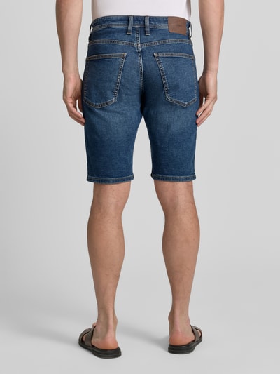 Männermodel trägt Regular Fit Jeans-Bermudas aus Baumwoll-Mix von s.Oliver RED LABEL, 5-Pocket-Design, Kontrastnähte, Ganzkörperansicht Rückansicht.