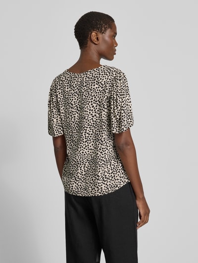 Frauenmodel trägt Bluse mit V-Ausschnitt Modell 'GRACE' von Vila im Straight Fit mit Knopfleiste, schwarz-beiges Punktemuster, Ganzkörperansicht Rückansicht.