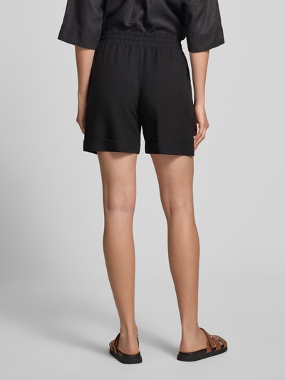 Kobiece model prezentuje Regular Fit Shorts aus Viskose-Mix Modell 'Malotta' od OPUS PANTS, czarne, mieszanka wiskozy i lnu, elastyczny pas z tunelem, długość wewnętrzna nogawki 16 cm, szerokość w rozmiarze 36: 40 cm, widok na całe ciało od tyłu