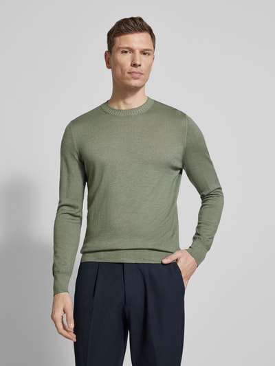 Männermodel trägt Strickpullover aus reiner Schurwolle von GRAN SASSO in Grün, körpernah geschnitten, Rundhalsausschnitt, Ganzkörperansicht von vorne