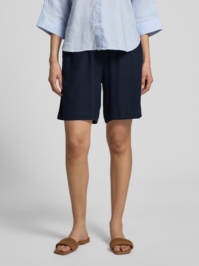 Frauenmodel trägt FREE/QUENT Leinenshorts mit elastischem Bund Modell 'Lava', dunkelblau, lockerer Schnitt, Nahaufnahme Oberkörper, Leinen-Mix mit Viskose-Anteil, französische Eingrifftaschen, Produktkontext.