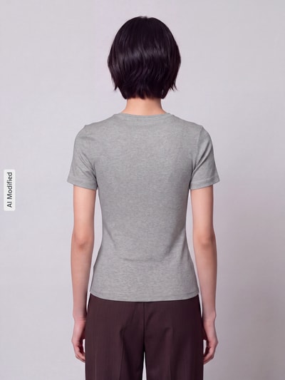 Frauenmodel trägt Slim Fit T-Shirt aus Baumwoll-Mix Modell 'RILEY' von ONLY in Grau, leichte Struktur, Damen T-Shirt von ONLY, Ganzkörperansicht Rückansicht, KI-modifiziertes Bild.