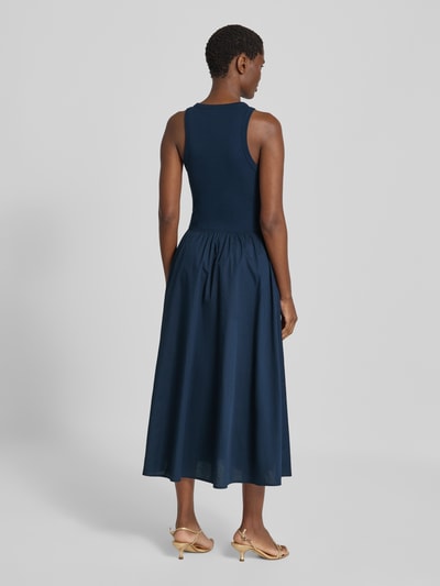 Frauenmodel trägt A-Linie Freizeitkleid aus reiner Baumwolle von Tommy Hilfiger in Dunkelblau, glatte Struktur, Ganzkörperansicht Rückansicht.