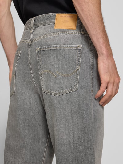 Männermodel trägt Straight Fit Jeans aus reiner Baumwolle im Used-Look von JACK & JONES, graue Denim mit 5-Pocket-Design, Ganzkörperansicht Rückansicht.