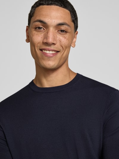 Männermodel trägt Regular Fit Pullover aus Viskose-Mix Modell 'WYLER' von ONLY & SONS in Dunkelblau, feine Struktur, Nahaufnahme Oberkörper.