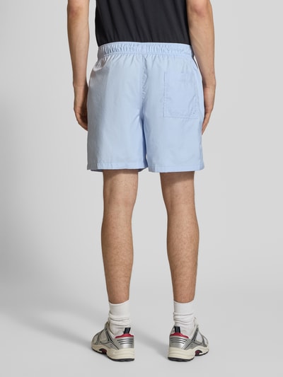 Männermodel trägt hellblaue Shorts mit Label-Stitching und elastischem Bund von Nike, Regular-Fit, Tunnelzug, Rückansicht Ganzkörperansicht.