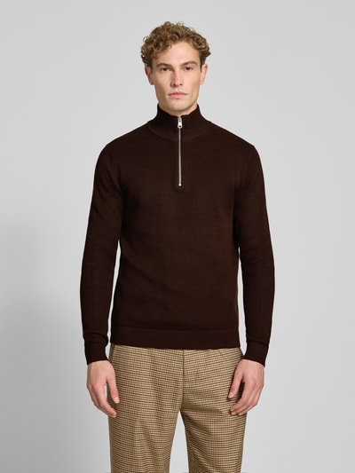 Männermodel trägt dunkelbraunen Regular Fit Troyer aus reiner Baumwolle Modell 'DANE' von Selected, beige karierte Hose, Ganzkörperansicht von vorne.