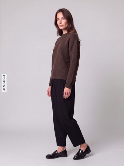 Frauenmodel trägt Regular Fit Pullover mit Woll-Anteil Modell 'ALLY' von PIECES in Braun zu schwarzer Hose, Ganzkörperansicht von vorne, KI-modifiziertes Bild.