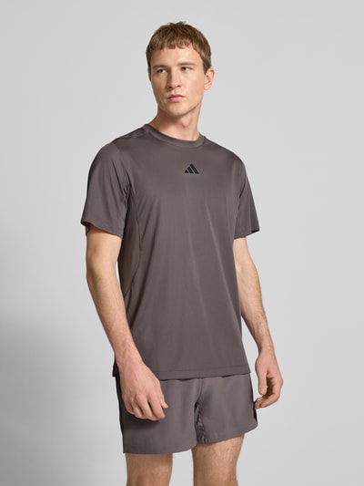 Männermodel trägt Regular Fit T-shirt met logoprint model 'Power' van adidas Training in taupe, ronde hals, ruglengte maat M 65 cm, Ganzkörperansicht van voren.