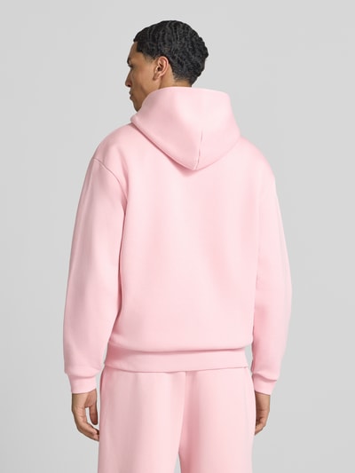 Männermodel trägt Sweatjacke aus Baumwoll-Mix von REVIEW in Hellrosa, lockere Passform, Rückenansicht, Ganzkörperansicht Rückansicht.