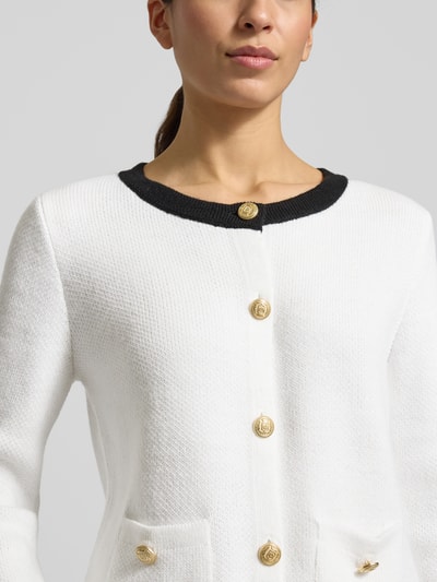 Vrouwenmodel draagt Slim Fit Jacke met wol-aandeel in tricotlook van More & More, materiaalmix, ronde hals, knoopsluiting, opgestikte zakken, Nahaufnahme Oberkörper.