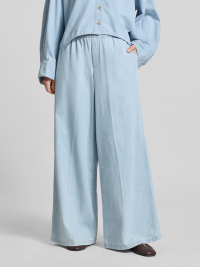Modelka kobieca nosi Wide Fit Stoffhose in Denim-Optik Modell 'Ceiling' od Drykorn, czysta bawełna, elastyczny pas, szerokość w rozmiarze 27/34: 36 cm, długość nogawki od wewnątrz 79 cm, jasnoniebieski kolor, luźna forma, gładka tekstura, zdjęcie całej sylwetki z przodu.