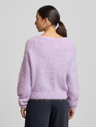 Frauenmodel trägt Strickpullover mit gerippten Abschlüssen Modell 'NIBY' von American Vintage in Flieder, locker geschnitten, Rückenansicht.