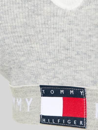 Frauenmodel trägt BH mit Logo Bund Modell 'RIB BRALETTE LIFT' von TOMMY HILFIGER, mehrfarbig, gerippte Struktur, Nahaufnahme Oberkörper.