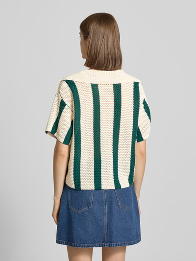Frauenmodel trägt Relaxed Fit Bluse aus reiner Baumwolle Modell 'KENZIE' von Pieces, grün-creme gestreift, Strickoptik, Ganzkörperansicht Rückansicht.