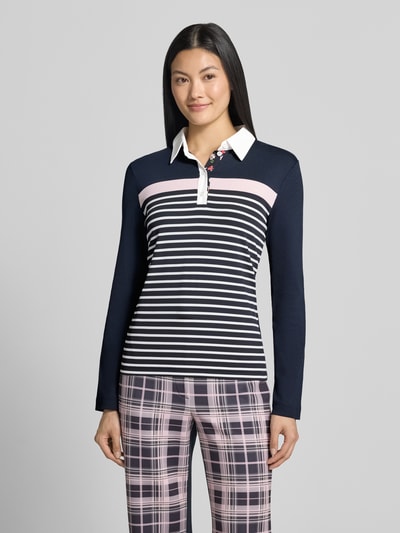 Modelka nosi Slim Fit Poloshirt aus Baumwoll-Mix von Marc Cain, mieszanka bawełny, kołnierzyk polo, z długim rękawem, długość tyłu w rozmiarze 36: 56 cm, wielokolorowy wzór w paski i kratkę, widok całej sylwetki z przodu.