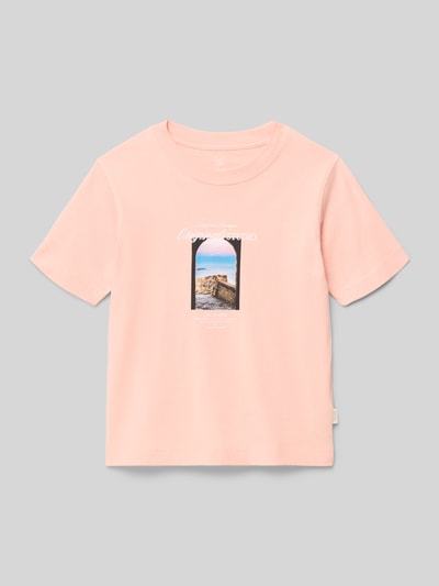 Meisje draagt T-shirt met motief- en statementprint model 'NORREBRO' van Jack & Jones van katoenmix, regular fit, ronde hals, labeldetail, ruglengte bij maat 140: 46 cm, in lichtroze, gladde structuur, rechte vormen, detailopname bovenlichaam.