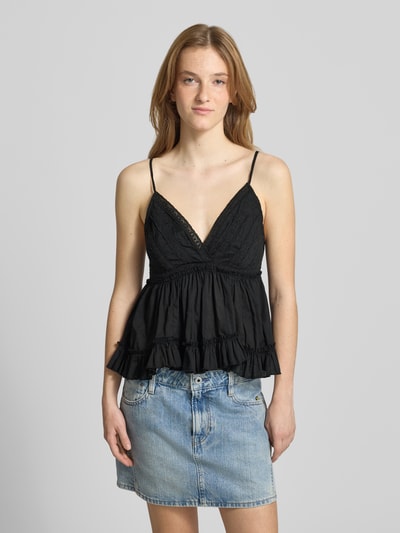 Frauenmodel trägt Slim Fit Top aus reiner Baumwolle Modell 'TARIA' von Only in Schwarz vor grauem Hintergrund, Ganzkörperansicht von vorne.