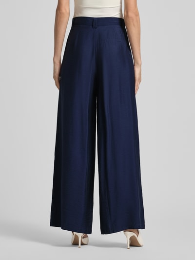 Frauenmodel trägt Wide Leg Stoffhose aus Viskose-Mix Modell 'FINJA' von GUIDO MARIA KRETSCHMER WOMAN, dunkelblau, feine Struktur, Falten, Ziertasche am Gesäß, Ganzkörperansicht Rückansicht.