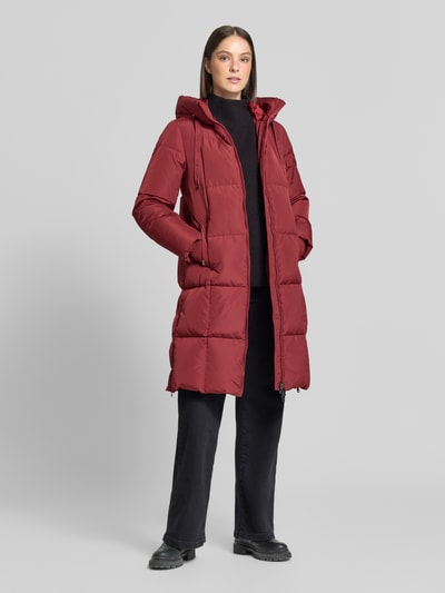 Frauenmodel trägt Regular Fit Mantel in Stepp-Optik Modell 'Nova' von MOS MOSH in Rot, Kapuze, Zweiwege-Reißverschluss, Eingrifftaschen, Ganzkörperansicht von vorne. Rückenlänge 102 cm, Schulterbreite 42 cm, Brustweite 46 cm, Ärmellänge 64 cm.
