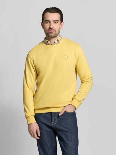 Männermodel trägt Sweatshirt mit Rundhalsausschnitt von Scotch & Soda in Gelb, Reine Baumwolle, Regular-Fit, Label-Stitching, Ganzkörperansicht von vorne.