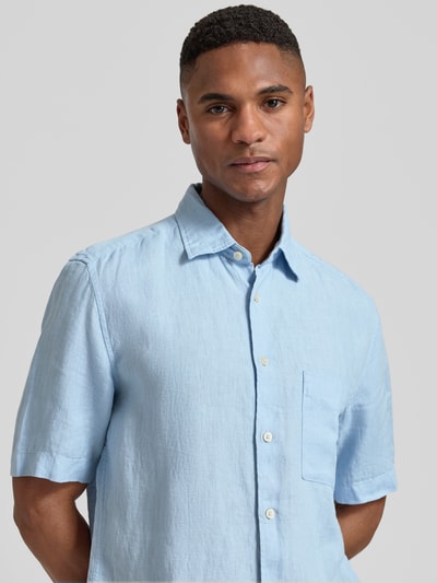 Männermodel trägt Regular Fit Freizeithemd aus reinem Leinen von Marc O'Polo, hellblau, Kentkragen, kurze Ärmel, Nahaufnahme Oberkörper.