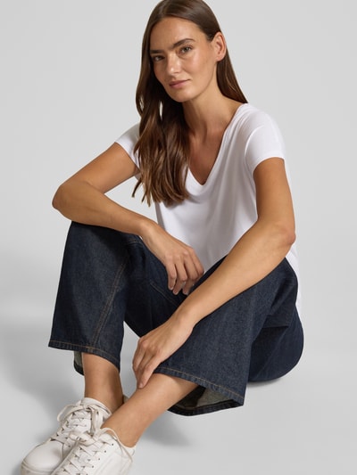 Frauenmodel trägt weißes Relaxed Fit T-Shirt aus Viskose-Mix von s.Oliver RED LABEL, kombiniert mit dunkler Jeans, Nahaufnahme Oberkörper.