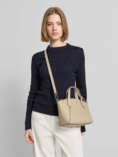 Modelka nosi Henkeltasche aus echtem Leder Modell 'LENAH' von BOSS w kolorze beżowym, faktura gładka skóra, widok z przodu, zbliżenie na górną część ciała.
