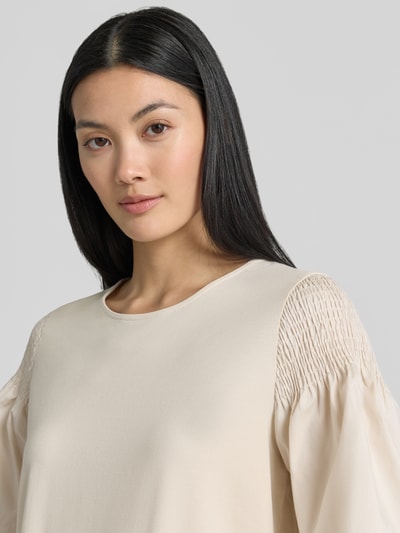 Frauenmodel trägt Regular Fit T-Shirt mit Smok-Detail von Comma aus reiner Baumwolle, ausgestellte Ärmel, kurzärmelig, Rundhalsausschnitt, Nahaufnahme Oberkörper.