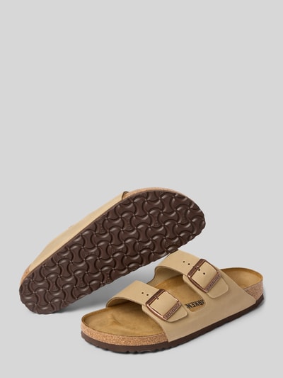 Produktfoto, Slides aus echtem Leder Modell 'ARIZONA' von Birkenstock in Beige mit profilierter brauner Sohle, abgerundete Form, breite Riemen, Dornschließe, offene Ferse, 4 cm Absatzhöhe, strukturierte Textur