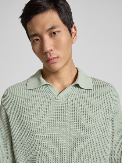 Männermodel trägt Relaxed Fit Strickpullover aus reiner Baumwolle Modell 'DERECK' von SELECTED HOMME in Mintgrün, unifarben, Grobstrick, Nahaufnahme Oberkörper.