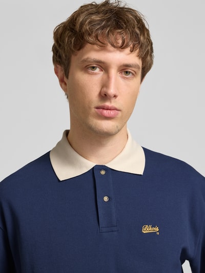 Männermodel trägt Regular Fit Piqué-Poloshirt mit Label-Stitching von BLKVIS, Baumwoll-Mix, Knopfleiste, Nahaufnahme Oberkörper.