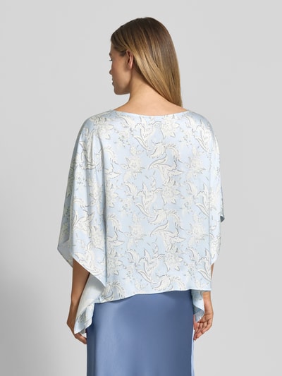 Modelka nosi Loose Fit Poncho-Bluse mit Allover-Muster von s.Oliver BLACK LABEL, efekt: wzór na całej powierzchni, krój loose fit, dekolt w łódkę, rękawy nietoperzowe, wykończenie materiału: tkanina, materiał: czysta wiskoza, jasnoniebieskie odcienie, subtelne kwiatowe wzory, z tyłu, całkowity widok sylwetki, Ganzkörperansicht Rückansicht.