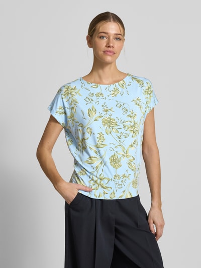 Frauenmodel trägt Relaxed Fit T-Shirt aus weichem Viskose-Mix von s.Oliver RED LABEL, Florales-Allover-Muster, U-Boot-Ausschnitt, Kurzarm, Optik:Allover-Muster, Pastellblau mit grünlichem Muster, glatte Textur, Damen T-Shirt, Ganzkörperansicht von vorne.
