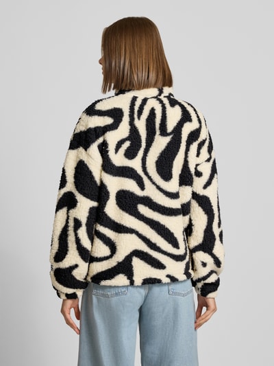 Frauenmodel trägt Regular Fit Jacke aus Teddyfell Modell 'Luca' von NOISY MAY®, schwarz-weiß gemustert, weiche Struktur, Ganzkörperansicht Rückansicht.