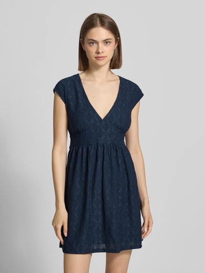 Frauenmodel trägt Kurzes Kleid mit V-Ausschnitt, Lochstickerei und großer Schleife von REVIEW, Dunkelblau, A-Linie, Material-Mix mit Stretch-Anteil, Damen Minikleid, Ganzkörperansicht von vorne.