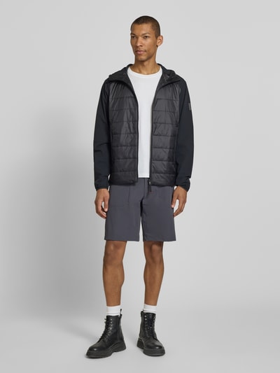 Männermodel trägt Shorts mit Reißverschlusstaschen Modell 'VIDAL2' von FIRE + ICE, grauer Material-Mix mit Stretch, Regular Fit, Ganzkörperansicht von vorne.