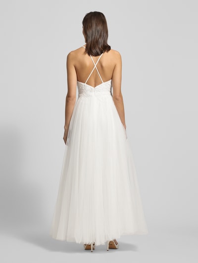 Modelka kobieca nosi Brautkleid mit floralen Stickereien od Mascara, biały, lekko rozkloszowany dół, hafty kwiatowe, przezroczysta warstwa, widok całej sylwetki z tyłu.
