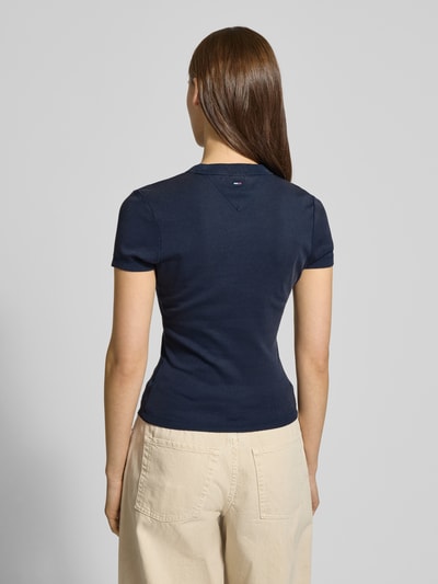 Vrouwenmodel draagt Slim Fit T-Shirt uit katoenmix model 'SLIM VARSITY' van Tommy Jeans, effen, labelprint, ronde hals, korte mouw, katoenmix, volledig zicht van achteren.