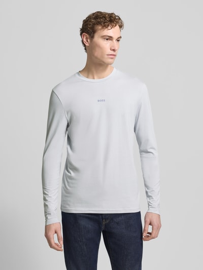 Männermodel trägt Regular Fit Langarmshirt aus Baumwoll-Mix Modell 'TCHARK' von BOSS Orange, Optik: Unifarben, Label-Print, Rundhals, Ärmelform: Langarm, Ganzkörperansicht von vorne.