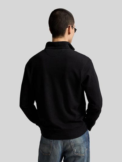 Männermodel trägt Regular Fit Sweatshirt aus Baumwoll-Mix von Polo Ralph Lauren in Schwarz, glatte Textur, Ganzkörperansicht Rückansicht.