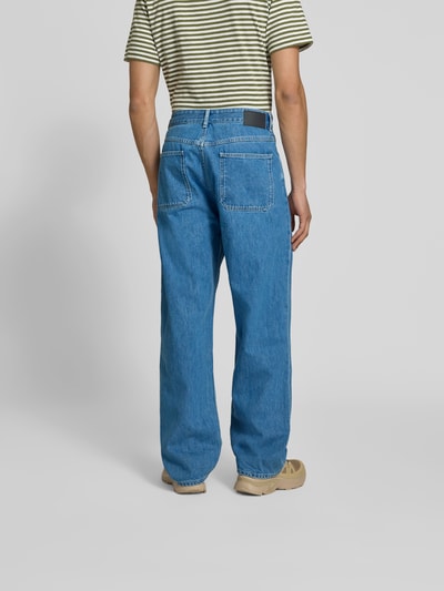 Männermodel trägt Straight Fit Jeans mit Logo-Patch von Closed in Blau, reine Baumwolle, sichtbare Gesäßtaschen, Ganzkörperansicht Rückansicht.