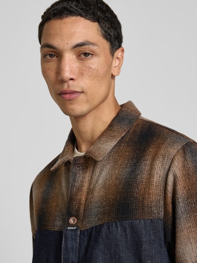 Männermodel trägt Slim Fit Hemdjacke aus reiner Baumwolle von Replay, Denim mit Umlegekragen und Knopfleiste, Nahaufnahme Oberkörper.