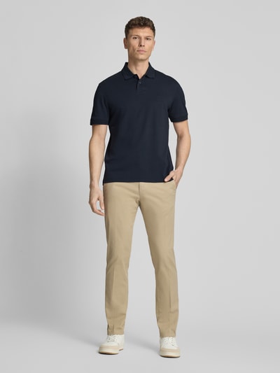 Männermodel trägt Regular Fit Poloshirt aus reiner Baumwolle Modell 'INTERLOCK' von BOSS Orange, Optik: Unifarben, Ganzkörperansicht von vorne.