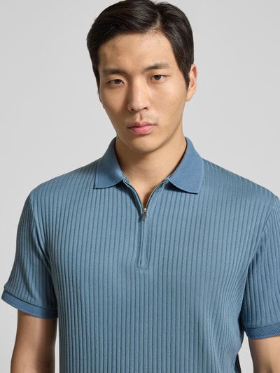 Męski model nosi Regular Fit Poloshirt mit Baumwoll-Anteil Modell 'FAVE' od SELECTED HOMME, niebieski, żebrowany materiał, krótki rękaw, krótki zamek, krój regular fit, widok z przodu, ujęcie: zbliżenie górnej części ciała.