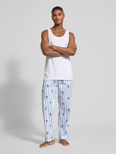 Männermodel trägt Comfort Fit Pyjama-Hose mit Polo-Bear-Muster Modell 'PJ PANT-SLEEP-BOTTOM' von Polo Ralph Lauren Underwear in Weiß-Blau mit Allover-Muster aus Baumwolle, elastischem Bund und seitlichen Taschen, Ganzkörperansicht von vorne.
