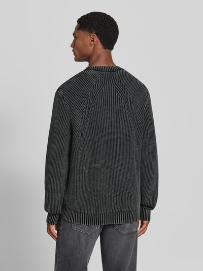 Męski model nosi sweter z dzianiny z prążkowanymi wykończeniami Strickpullover mit gerippten Abschlüssen von Antony Morato, bawełna, krój regular fit, Długość tyłu w rozmiarze M: 70 cm, Długość rękawów w rozmiarze M: 69 cm, widok całej sylwetki z tyłu.