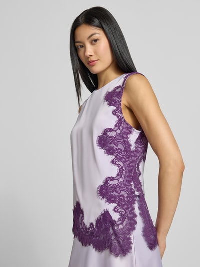 Frauenmodel trägt Top mit Spitzenbesatz Modell 'PELLA' von YAS in Flieder und Lila, Material-Mix, asymmetrisch, Nahaufnahme Oberkörper.