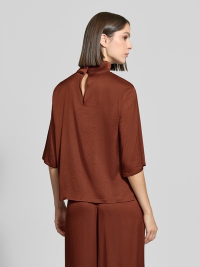 Frauenmodel trägt Regular Fit Bluse mit Stehkragen Modell 'Aletia' von DRYKORN, rötlich-brauner elastischer Acetat-Mix, Rückenansicht.